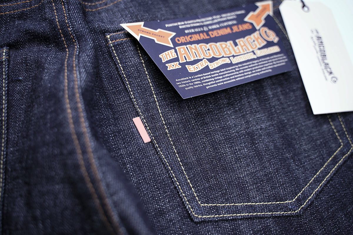 Close-up of back pocket arcuate stitching, sunfading red tab, and raw denim slub texture on Ancoblack 3700XX