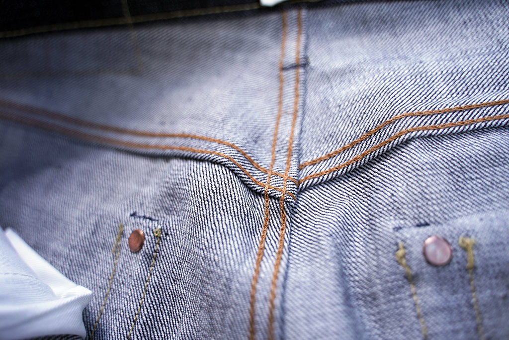 Ancoblack 4700xx back waist view with leather patch hidden rivets on dark raw denim
